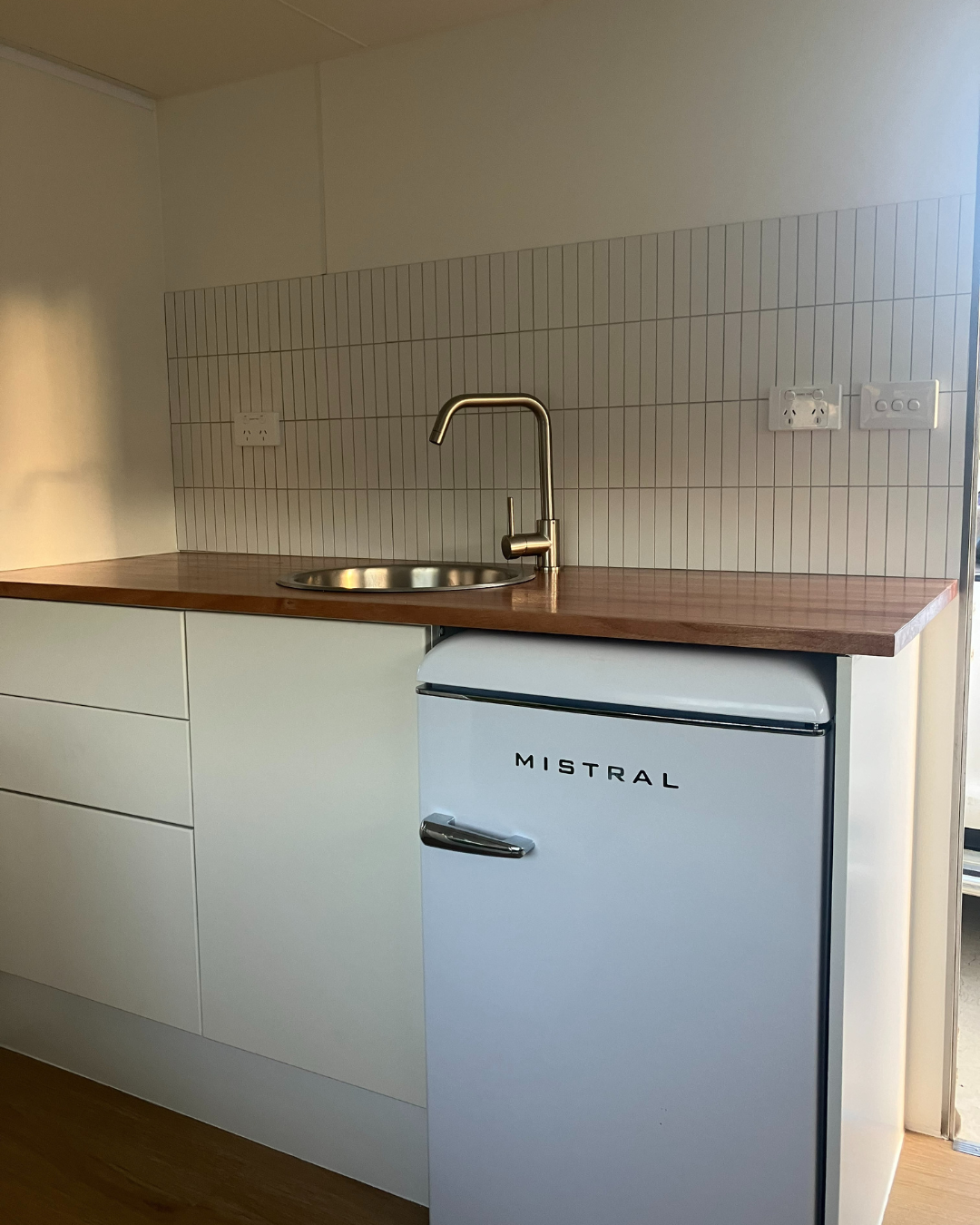 Compact kitchen setup with Matte White Kit Kat Stick on Composite Tiles as a backsplash, enhancing the space with a clean, modern finish.
