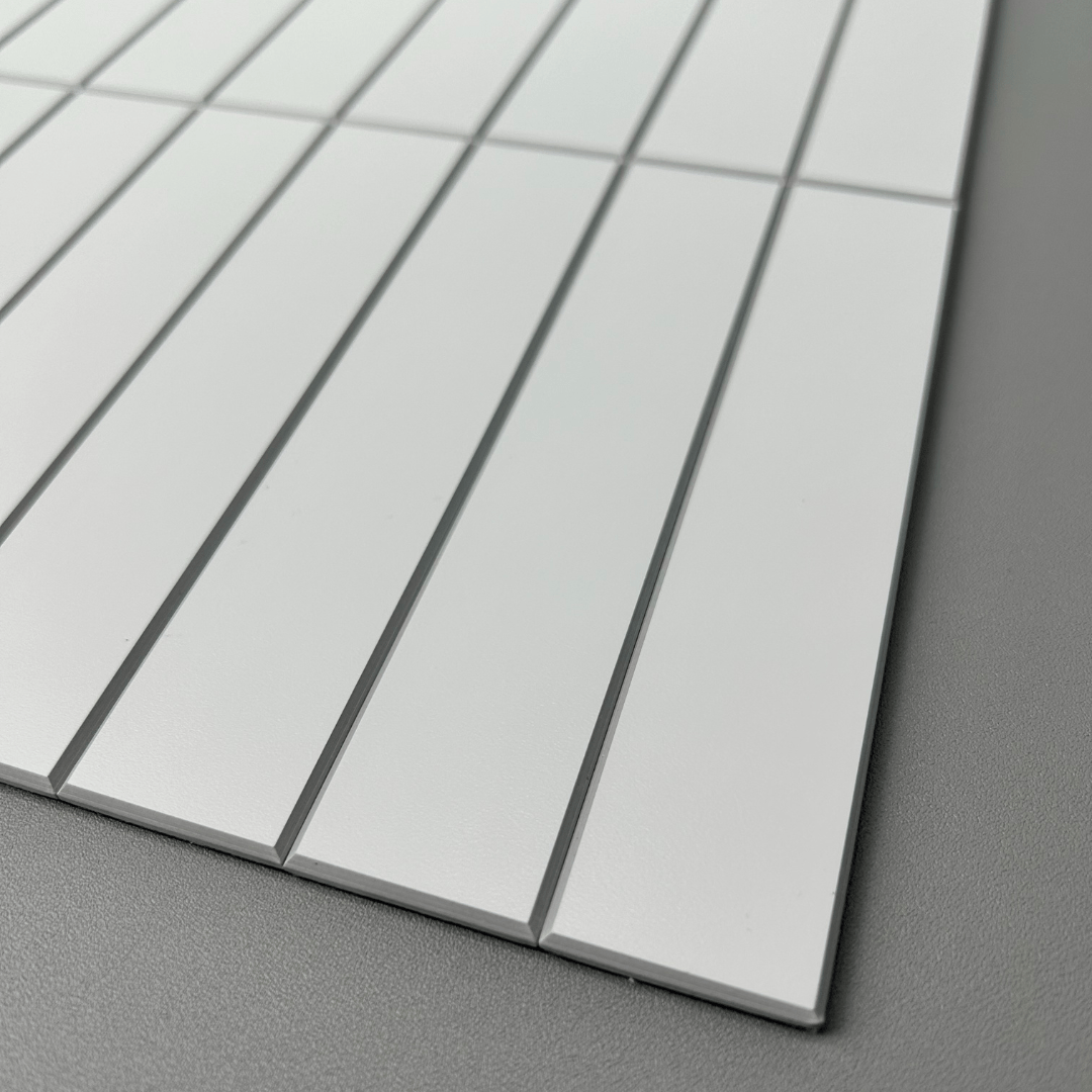 Angled view of Kit Kat Stick on Composite Tile in Matte White, highlighting its textured surface and precise tile spacing.
