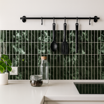 Kitchen with green marble tile backsplash, black utensils, and white countertops.