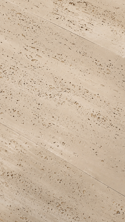 Beige travertine stone tile with natural porous texture and diagonal seams.