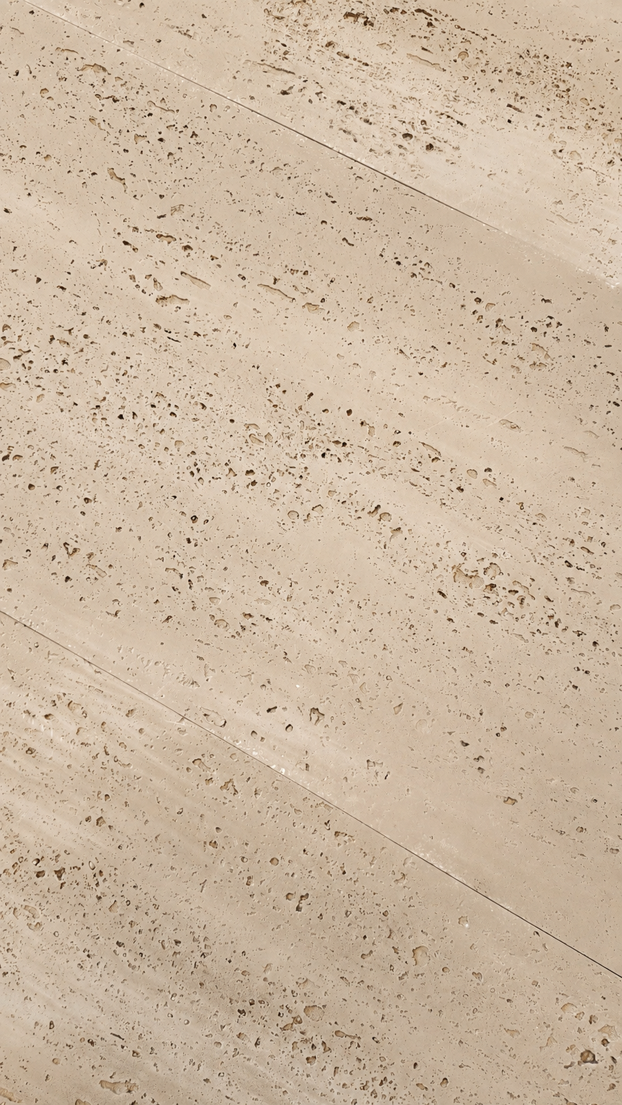 Beige travertine stone tile with natural porous texture and diagonal seams.