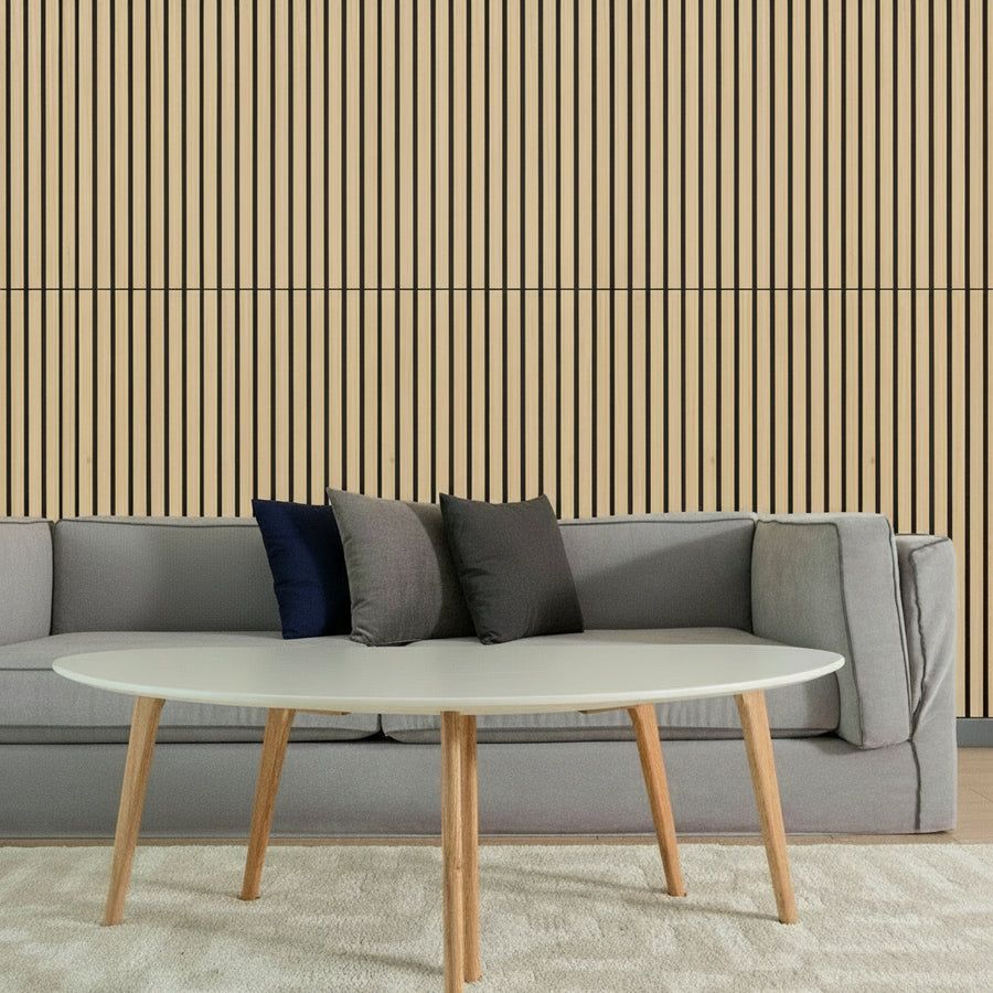 Gray sofa with colorful cushions and a white coffee table in front of a striped wall.